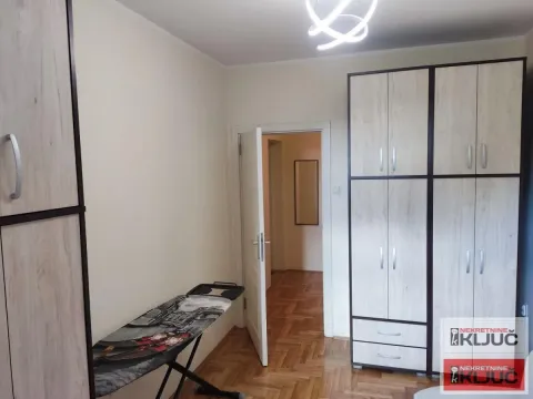 Spavaća soba sa ugradnim ormanima i parketom na podu. - image 7