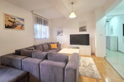 Living room with a sectional sofa, TV, and parquet flooring. - image 2
