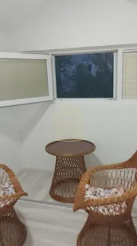 Small enclosed balcony with wicker furniture and windows. - image 2