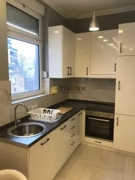 Small bright kitchen with white cabinets and a built-in oven. - image 9
