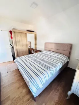 Spavaća soba sa bračnim krevetom i drvenim ormarom. - image 10