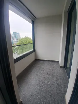 Prazna natkrivena terasa sa staklenom ogradom i pogledom na grad. - image 11