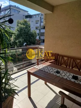 Nameštena terasa sa garniturom za sedenje i pogledom na okolne zgrade. - image 16