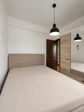 Moderna spavaća soba sa bračnim krevetom, garderoberom sa ogledalom i visećom lampom. - image 5