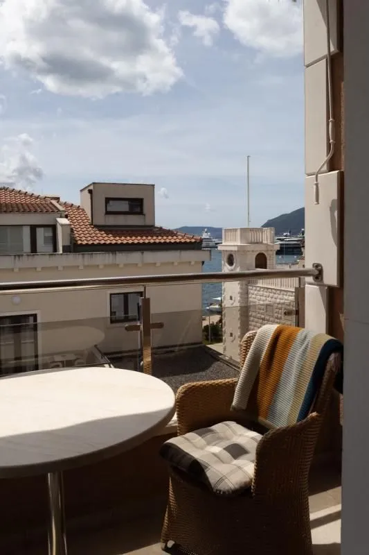 Manji namješteni balkon sa pogledom na more i okolne zgrade.