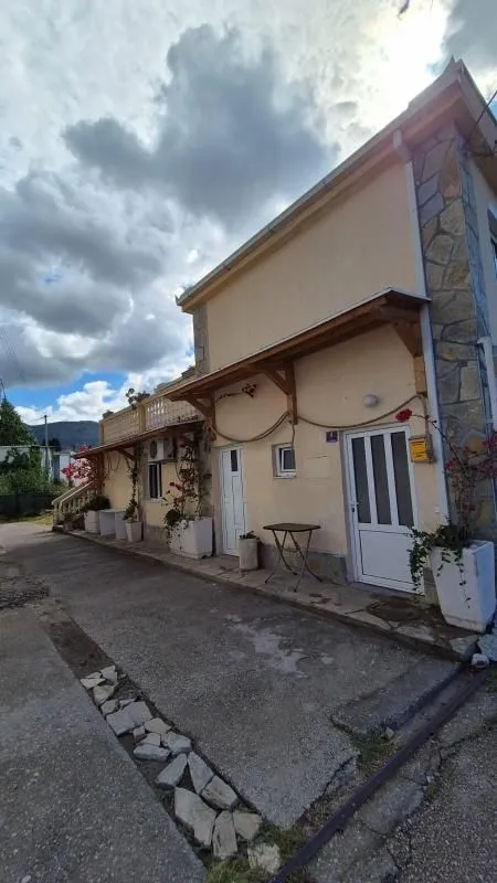 Exterior view of the house with a courtyard and entrance doors.