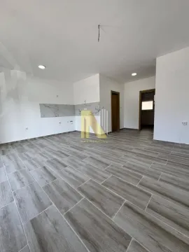 Prazna prostorija sa svetlim zidovima i pločicama u imitaciji drveta. - image 2