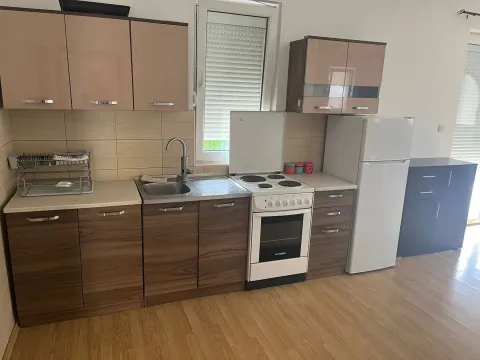 Manja kuhinja sa drvenim elementima, štednjakom i frižiderom. - image 6