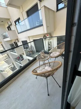 Furnished terrace with seating furniture and a view of the building. - image 6