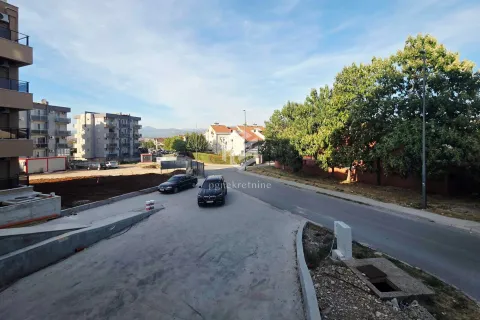 Pogled iz objekta na ulicu, parkirana vozila i okolne zgrade. - image 8