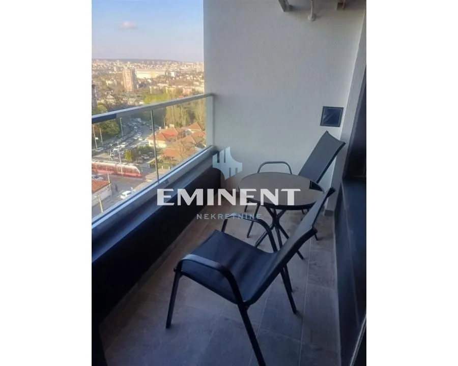 Furnished balcony with a table and chairs and a city view.
