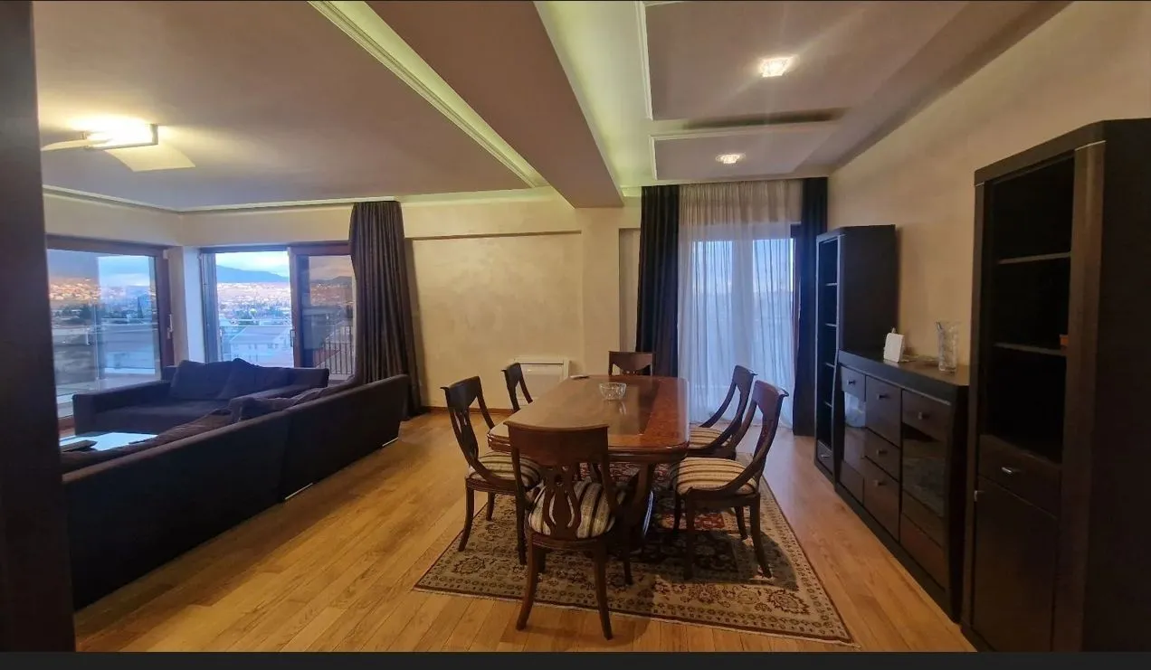 Spacious living room with a dining table and dark furniture.