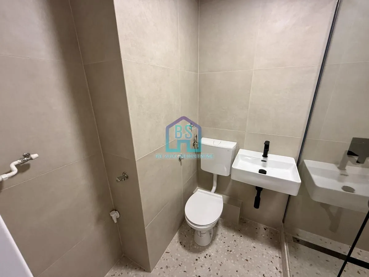 Savremeno opremljeno kupatilo sa sanitarijama i tuš kabinom.