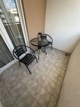 Small furnished balcony with a small table and two chairs. - image 10