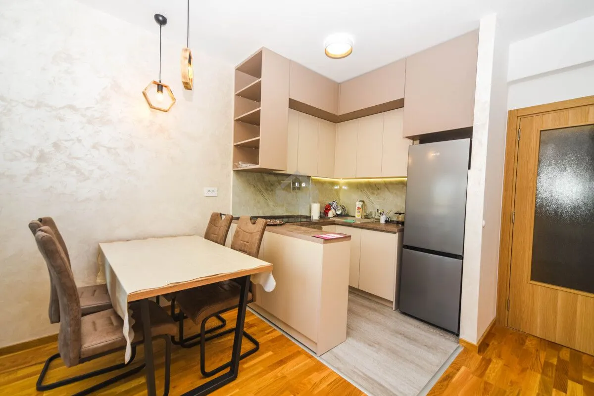 Kitchen with dining area and modern cabinets in beige tones.