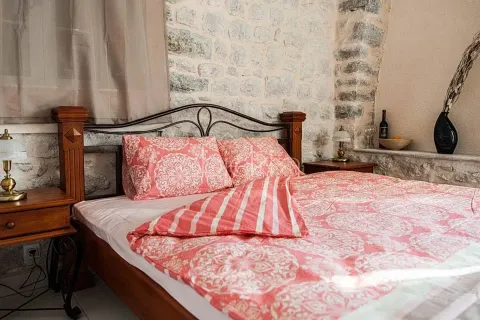 Bedroom with a double bed and a stone wall. - image 10