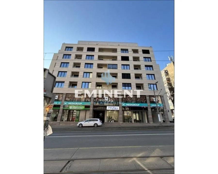 View of the exterior of a residential and commercial building with ground floor shops.