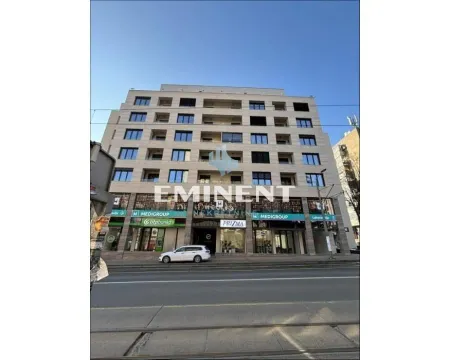 View of the exterior of a residential and commercial building with ground floor shops. - image 2
