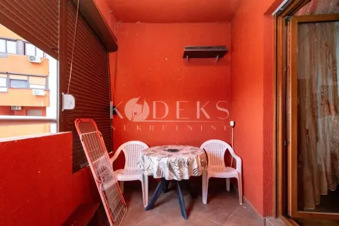 Covered terrace with red walls and a small table with two chairs. - image 8
