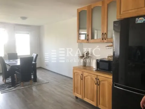 Wooden kitchen with dining area and a black refrigerator. - image 6