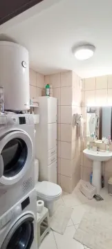 Kupatilo opremljeno sanitarijama, tuš kabinom i mašinama za pranje veša. - image 5