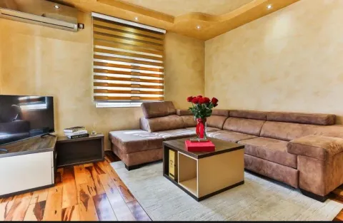Living room with a corner sofa, coffee table, television, and window with blinds. - image 14