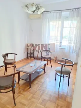 Dnevni boravak sa garniturom za sedenje i drvenim podom. - image 3