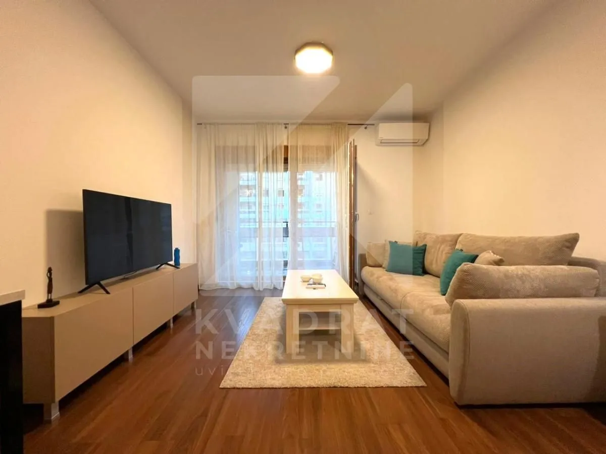 Living room with a sofa, TV, and access to the terrace.