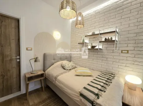 Small bedroom with a bed, decorative wall, and shelves. - image 12