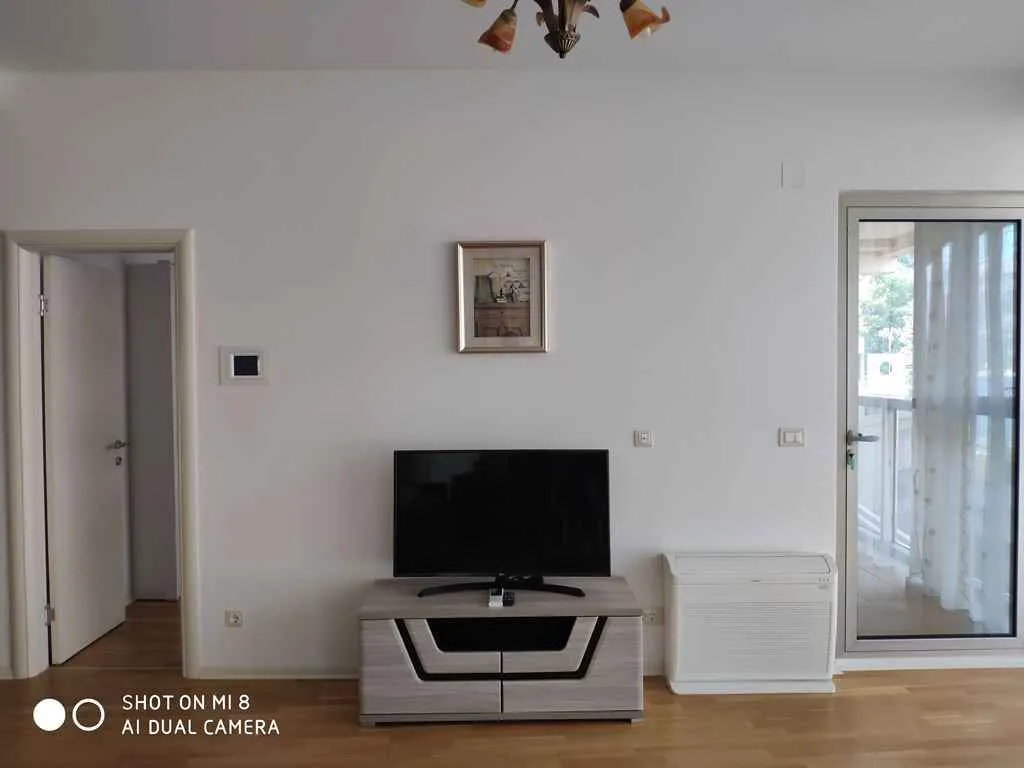 Bright living room featuring a TV stand and balcony access.