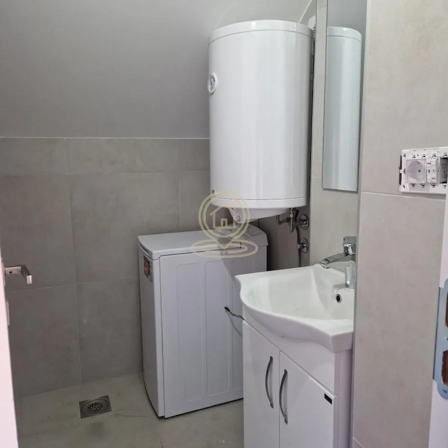 Bathroom equipped with a washbasin, water heater, and washing machine.