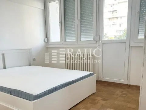 Bright bedroom with a white bed and parquet flooring. - image 2