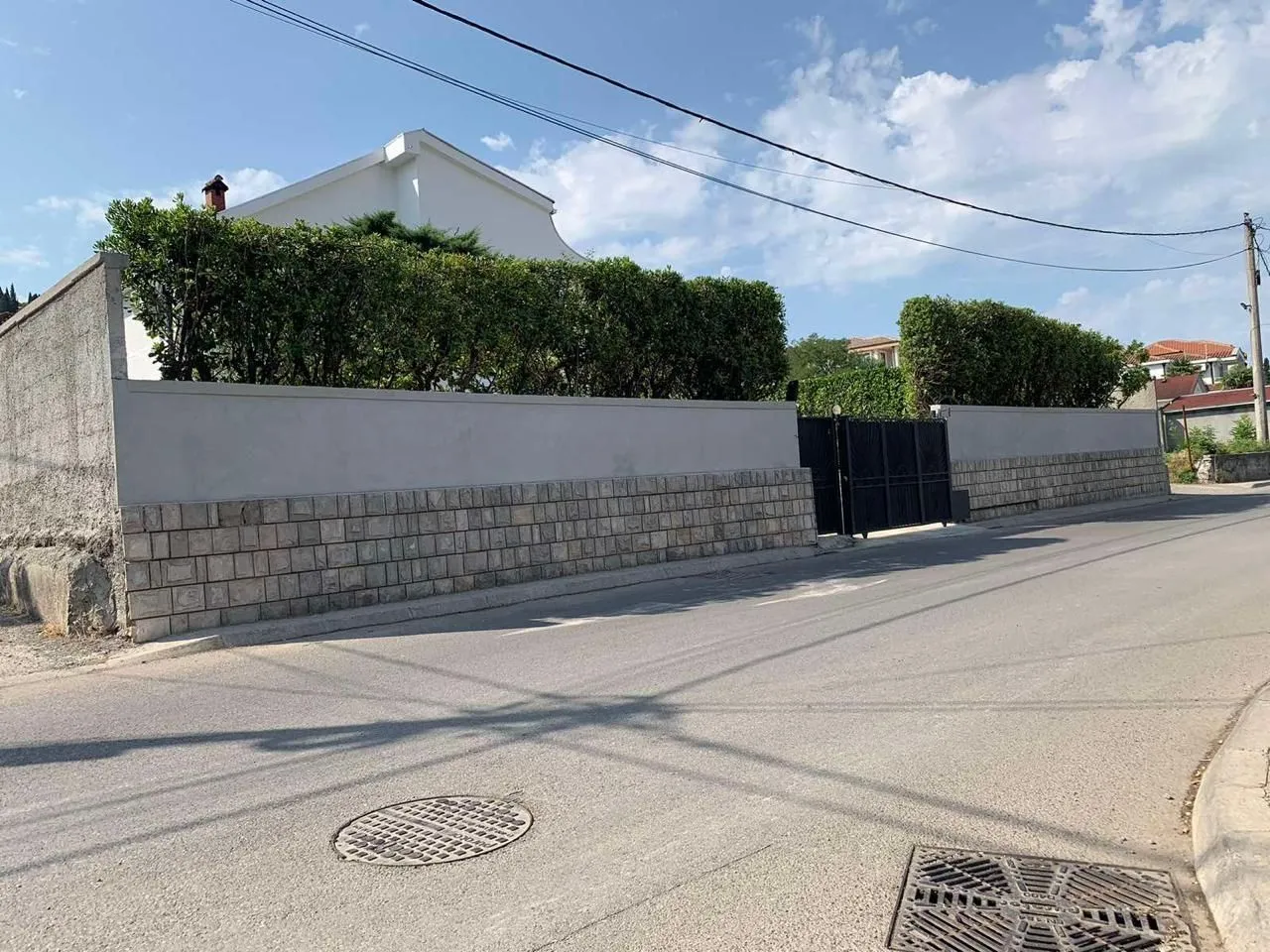 View of the property's exterior wall and gate from the street.