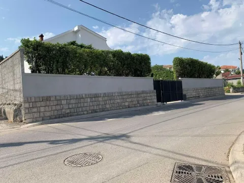 View of the property's exterior wall and gate from the street. - image 12