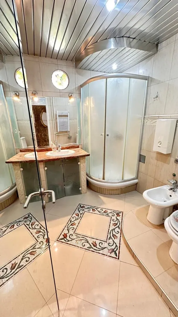Fully equipped bathroom with a shower cabin, washbasin, and sanitary fixtures.