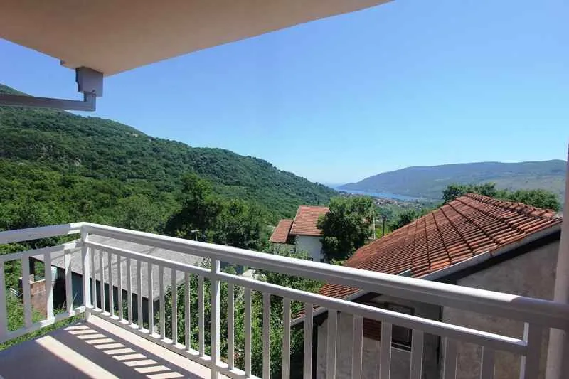 Pogled sa terase na planine i okolne kuće.