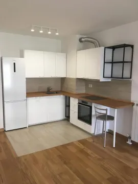 Kitchen equipped with white cabinets, built-in appliances, and a refrigerator. - image 3