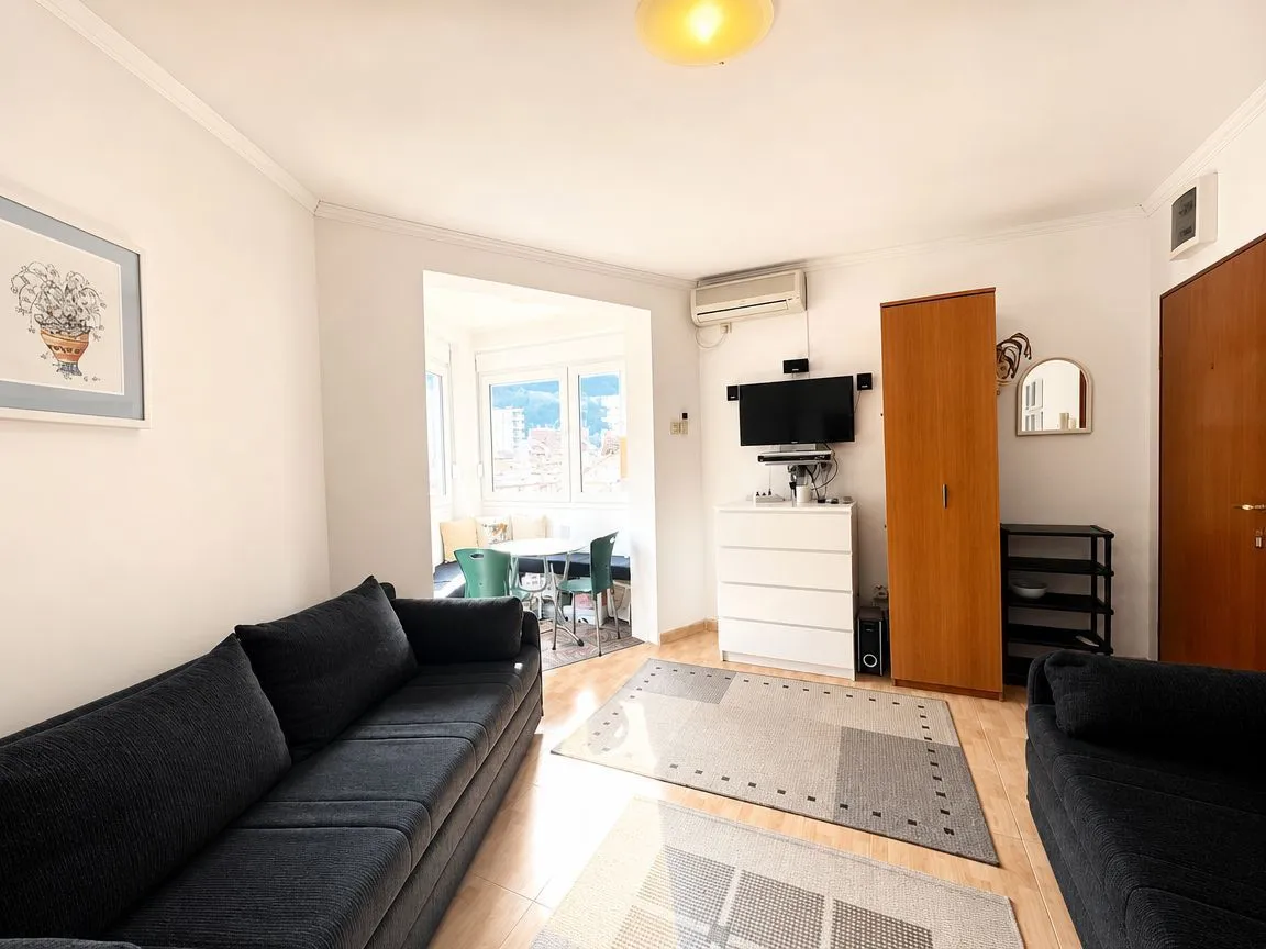 Living room with a sofa set, chest of drawers, and television.
