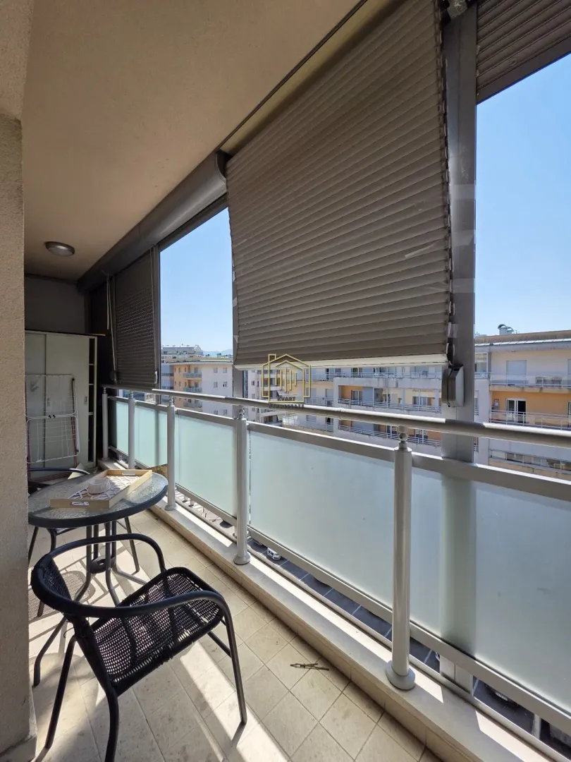 Furnished balcony with a table and chairs and a view of the surrounding buildings.