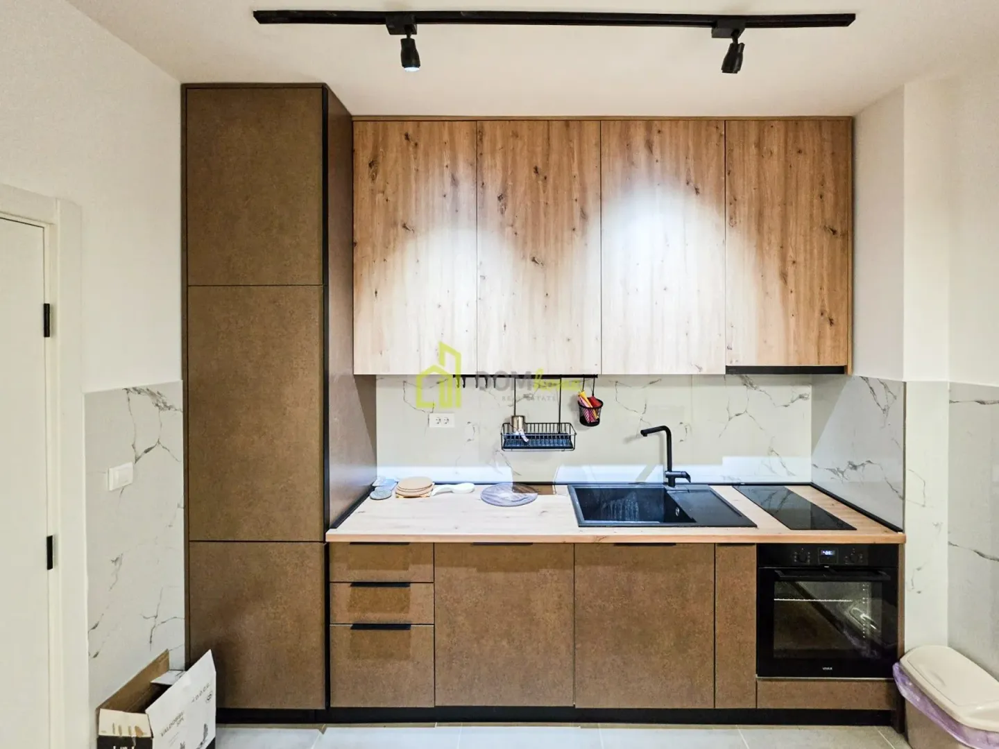 Modern kitchen with wooden cabinetry, a sink, and a built-in oven.