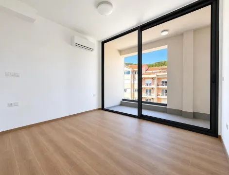 Prazna soba sa laminatom i velikom staklenom stenom koja izlazi na terasu. - image 11