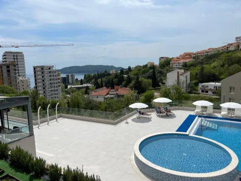 Pogled sa terase na bazen i okolne zgrade sa zelenilom. - image 8