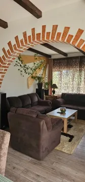Living room with sofa set, coffee table, and decorative brick archway. - image 9