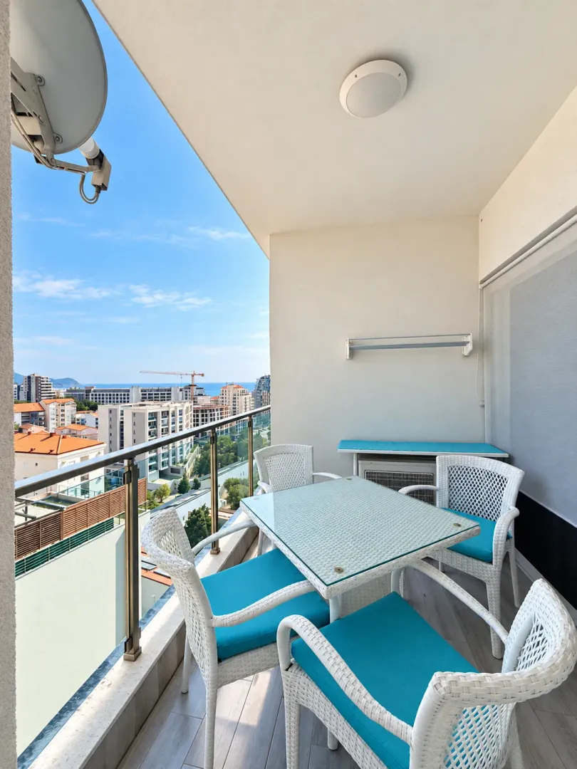 Furnished terrace with a dining table, chairs, and a city view.