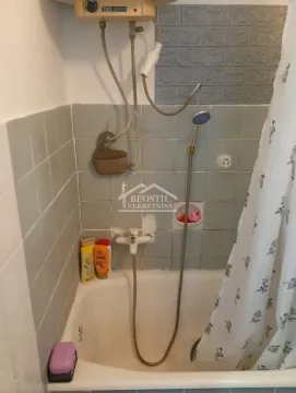 View of the bathtub with shower and wall tiles in the bathroom. - image 13