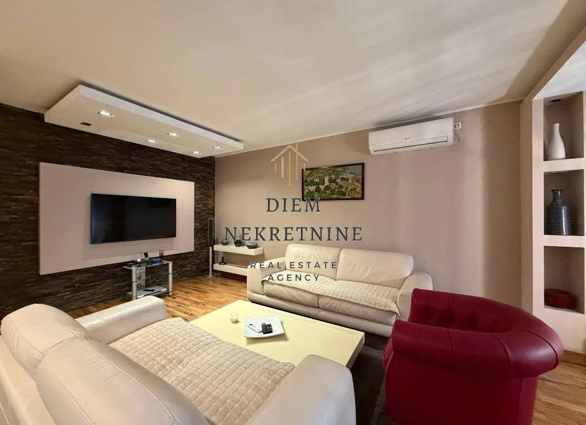 Spacious and furnished living room with a sofa set and a TV.