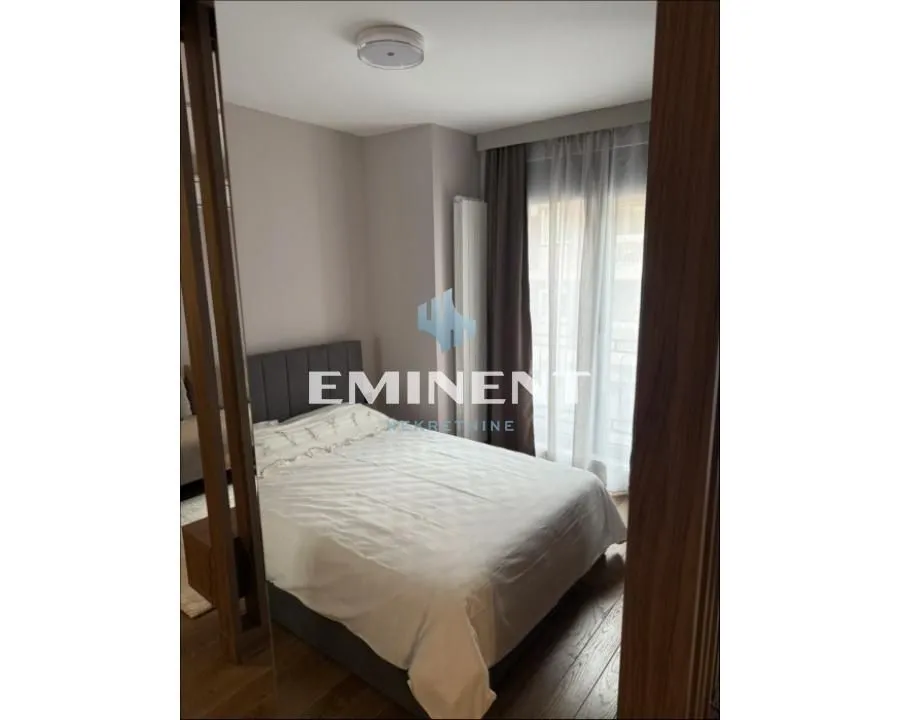 Master bedroom with a double bed and a window with curtains.