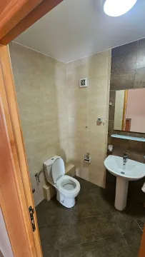 Manje kupatilo obloženo keramičkim pločicama sa toaletom i umivaonikom. - image 12