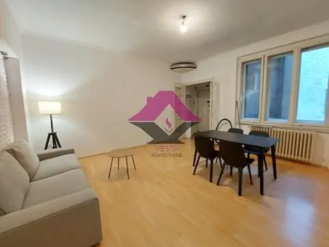 Spacious living room with a sofa set, dining table, and hardwood flooring.