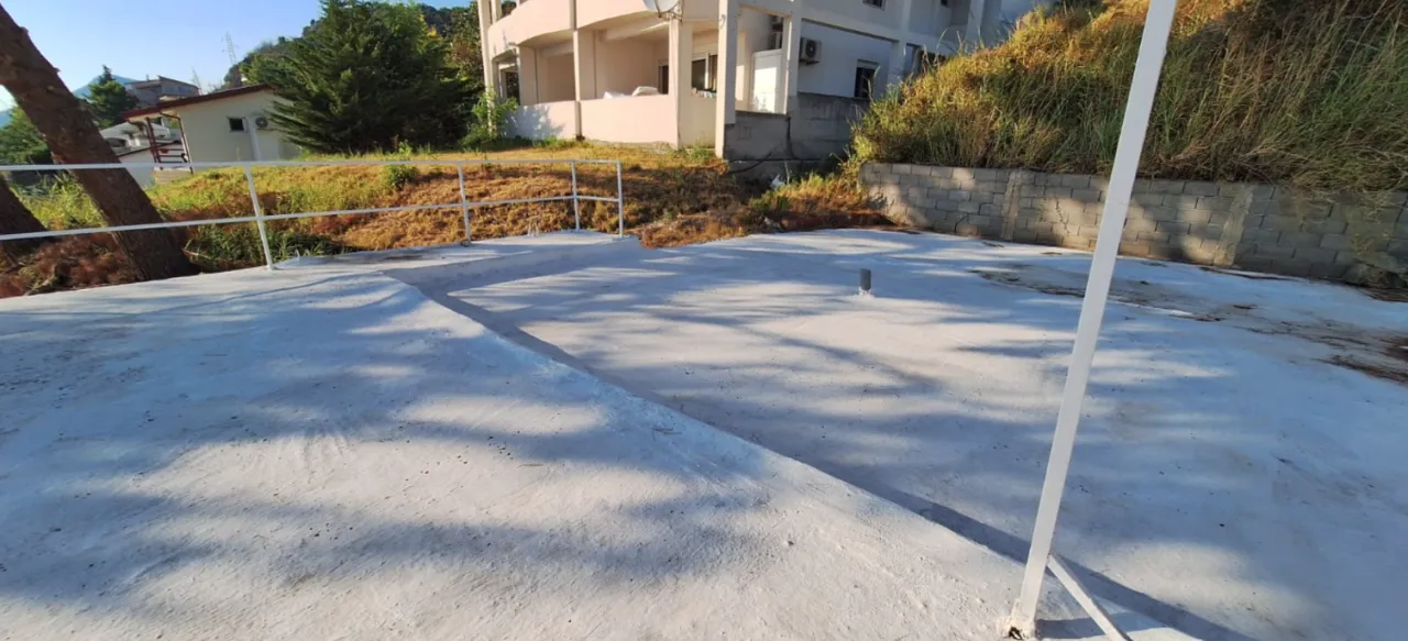 Betonska terasa sa ogradom ispred zgrade.